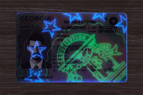 Georgia novelty driver’s license glowing under UV light with blue stars and green security patterns